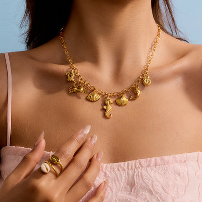 Model wearing a layered seashell and dolphin charm necklace in gold tone