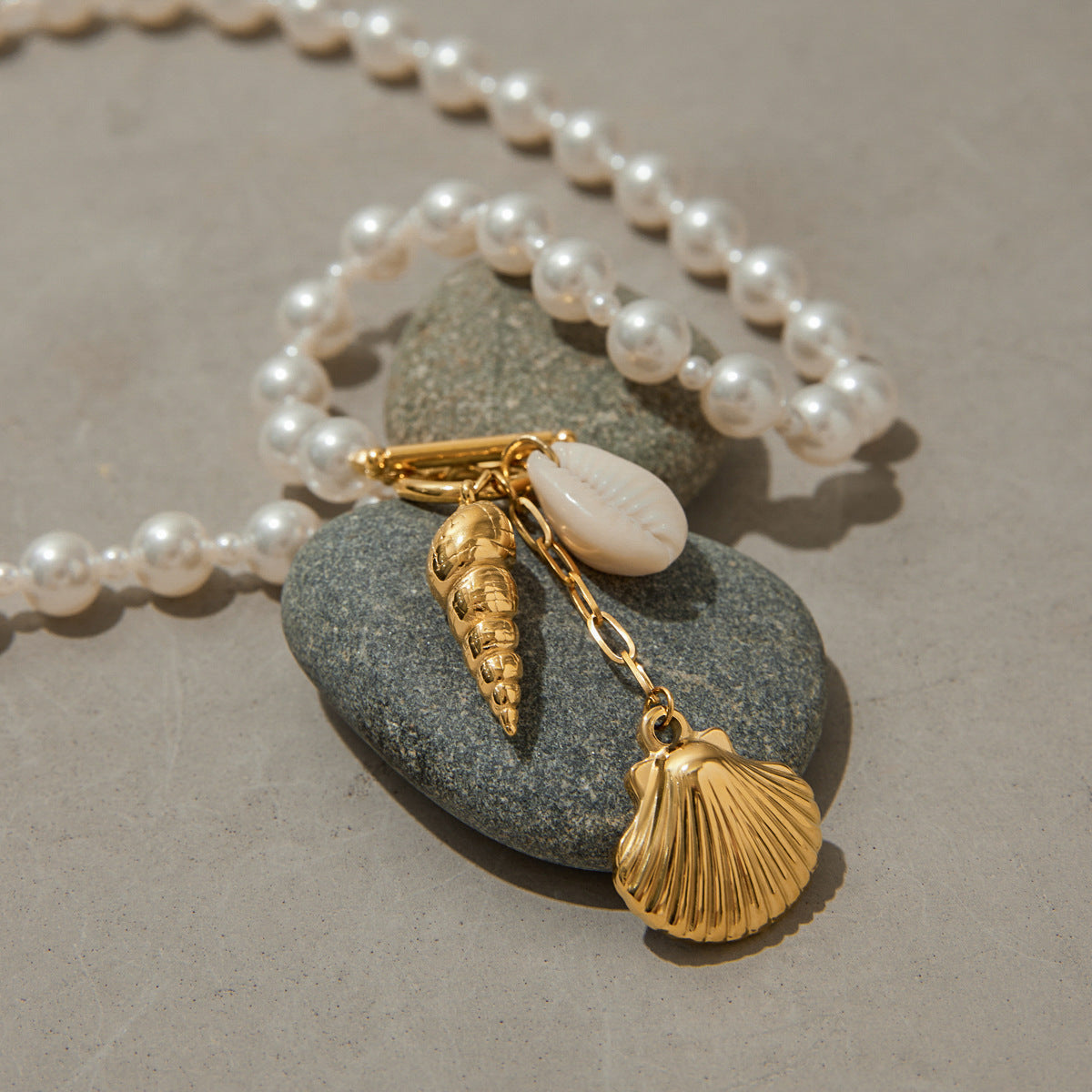 Close-up shot of pearl beaded necklace with gold conch and scallop shell details