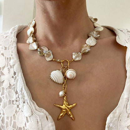 Close-up of waterproof pearl and shell necklace on a white lace top