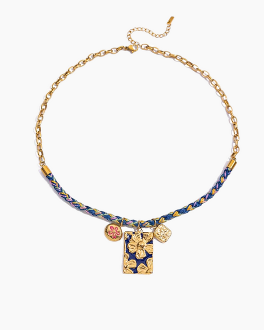Necklace with blue braided cord and gold accents on a white background
