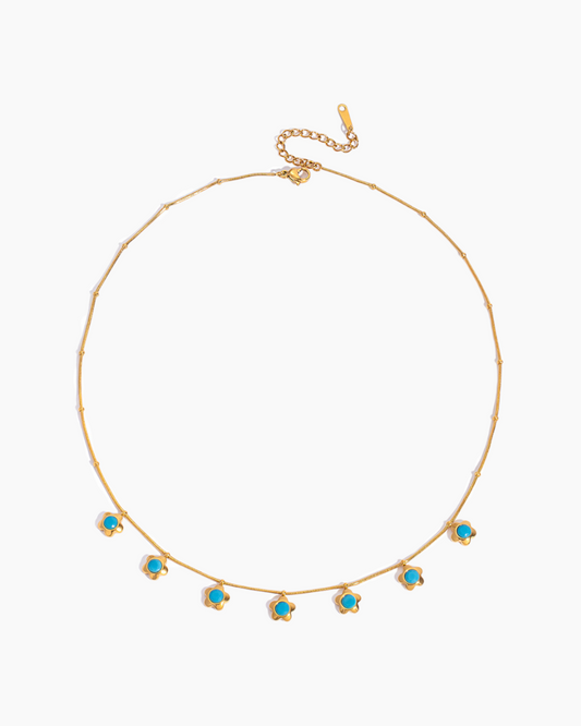 Gold necklace with turquoise stones on a white background