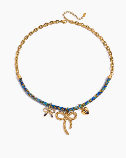 Necklace with gold bow charms and blue beads on a white background