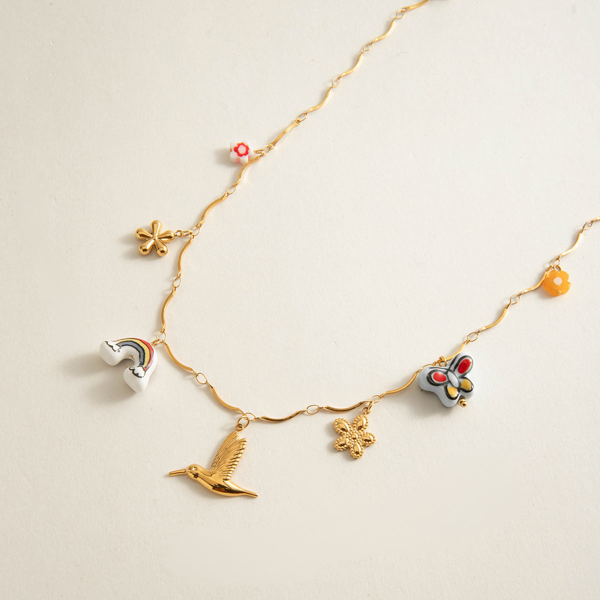 Close-up of handcrafted charms: rainbow, butterfly, flower, hummingbird, clover and yellow blooms