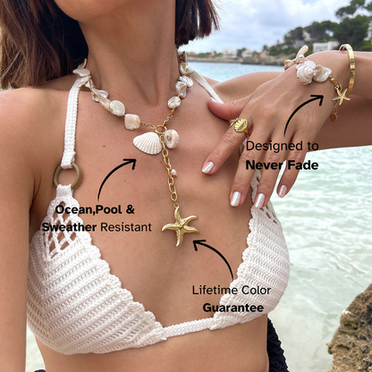 Woman wearing gold starfish shell necklace by the ocean, beach jewelry lifestyle