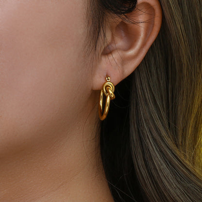 Model wearing knotted hoops styled with casual outfit and loose waves