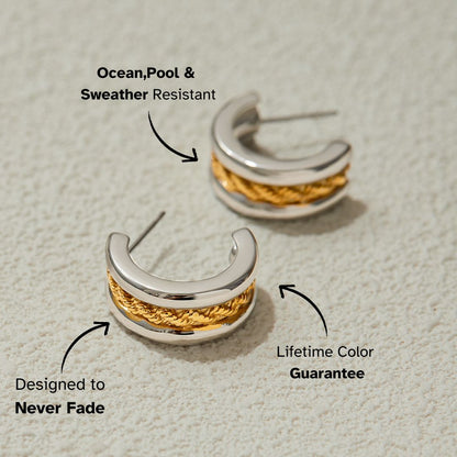Close-up of gold and silver braided hoop earrings on textured background