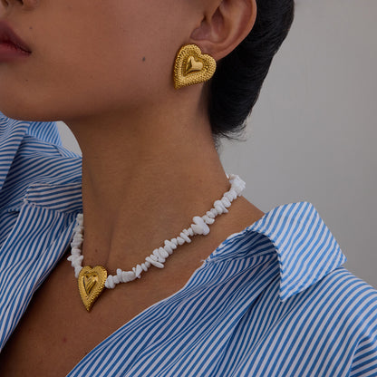 Matching gold heart necklace and earrings styled on model