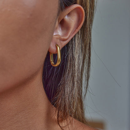 Oval gold hoop earrings laying flat, never tarnish design