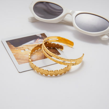 Gold headbands on a white surface with sunglasses and a photo in the background