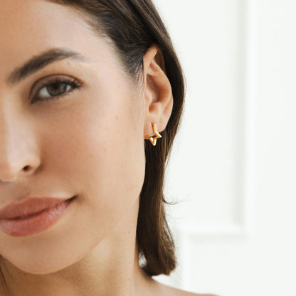 Model wearing small star hoop earrings with sleek hairstyle