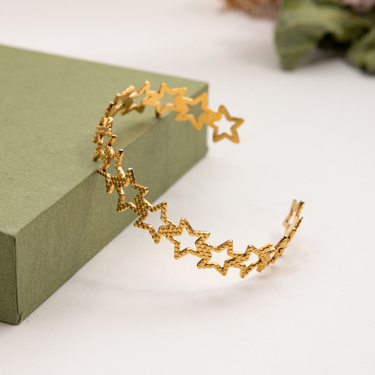 Close-up of waterproof gold bracelet with star cutouts