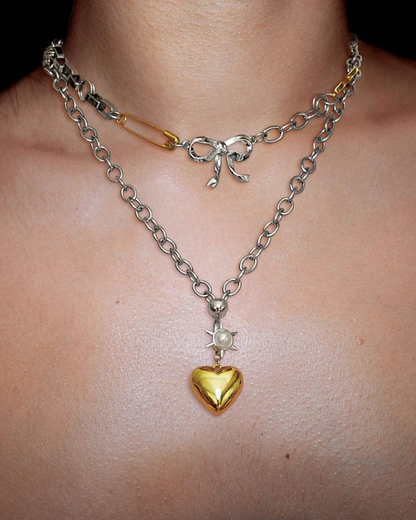 Necklace with a gold heart pendant and chain on a person's neck