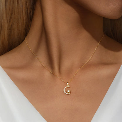 Gold moon and star pendant necklace on model in white outfit, dainty celestial jewelry.