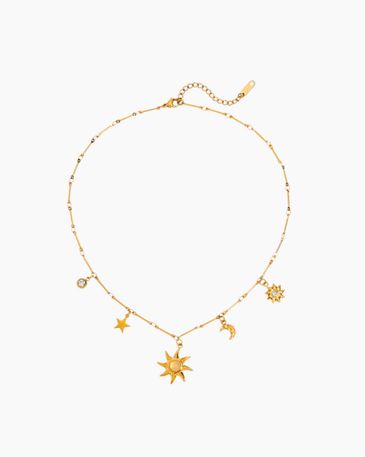 Gold necklace with star and moon charms on a white background