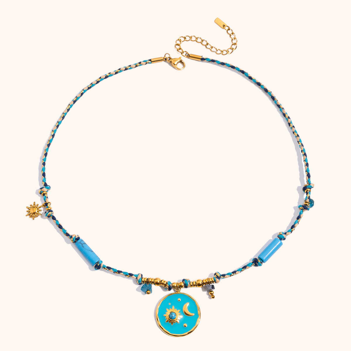 Close-up of celestial sun and moon charm on turquoise braided necklace
