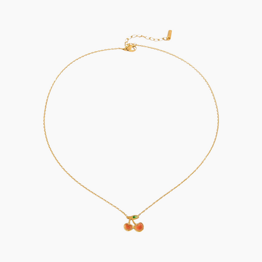 Gold necklace with cherry pendant on a white background
