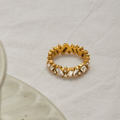 Statement baguette CZ gold ring shot on beige fabric with soft shadow detail