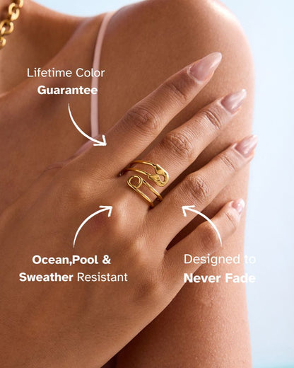 Model wearing gold safety pin ring and gold star necklace on shoulder close-up