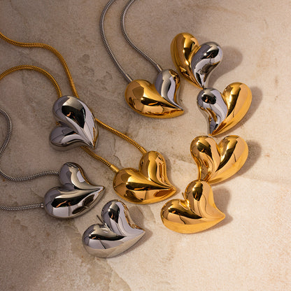 Display of multiple chunky heart earrings and necklaces, elegant mix of metals