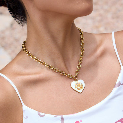 Model wearing retro gold chain with heart-shaped sun charm in outdoor setting