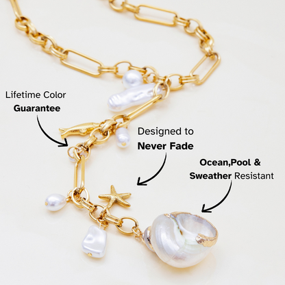 Gold chain necklace with pearls and charms on a white background