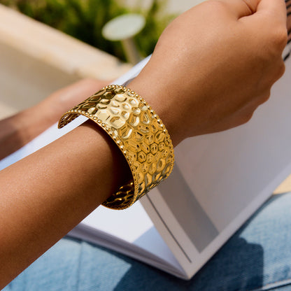 Close-up of waterproof chunky gold cuff bracelet styled with a yellow bikini