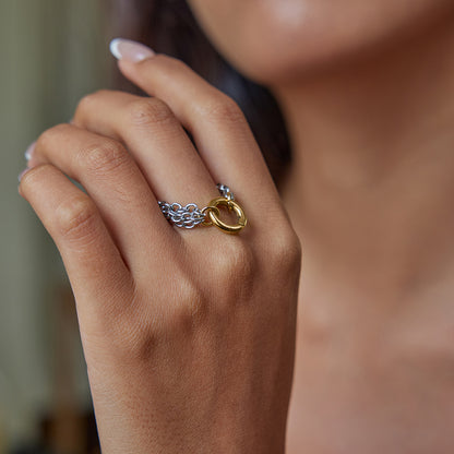 Model wearing bold silver chain ring with golden round clasp