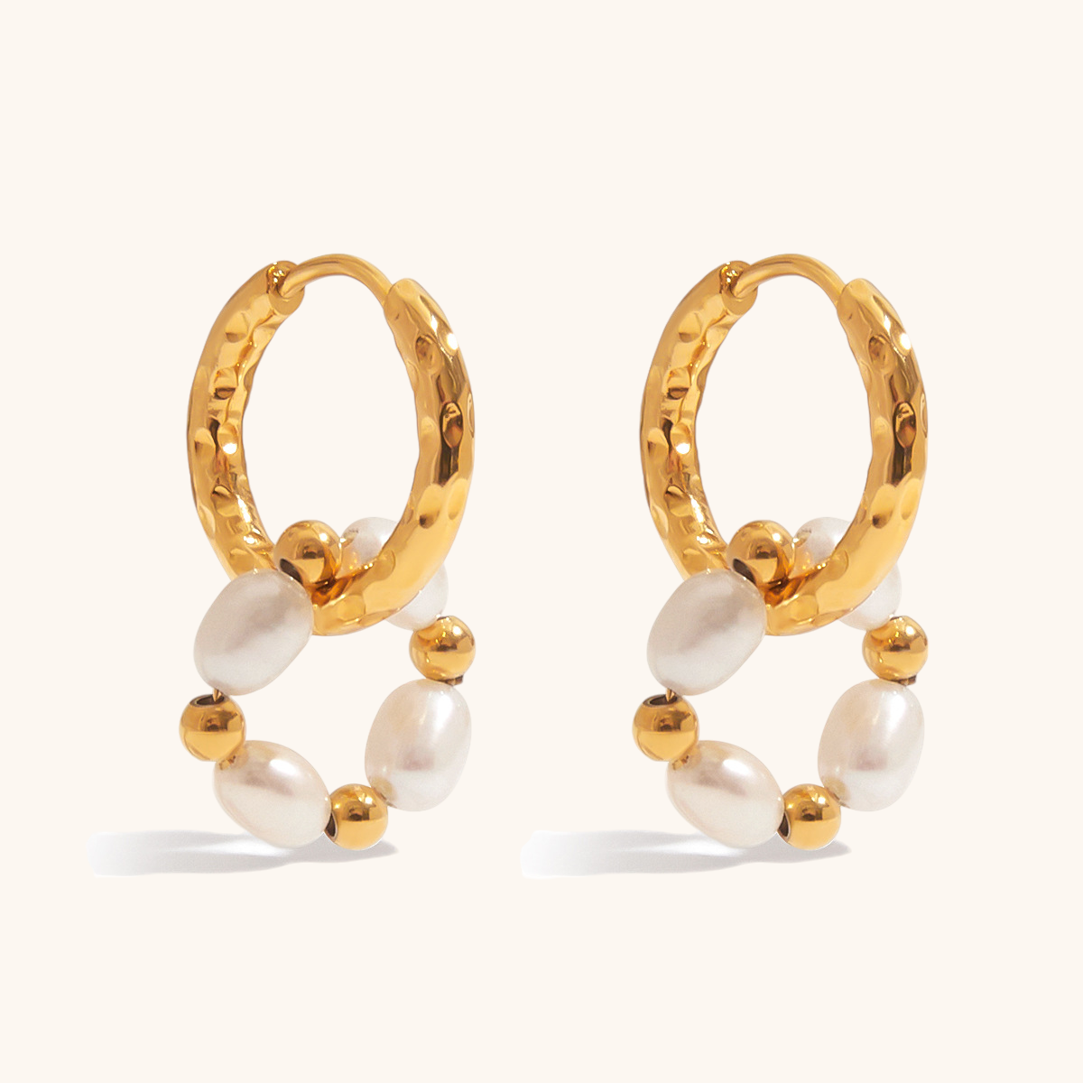 Close-up of gold hoop earrings with freshwater pearls and gold beads on a light cream background, ideal for daily wear.