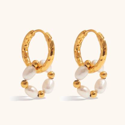 Close-up of gold hoop earrings with freshwater pearls and gold beads on a light cream background, ideal for daily wear.