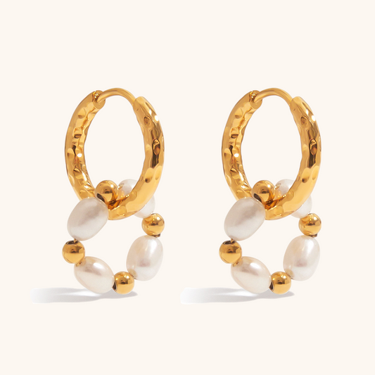 Close-up of gold hoop earrings with freshwater pearls and gold beads on a light cream background, ideal for daily wear.