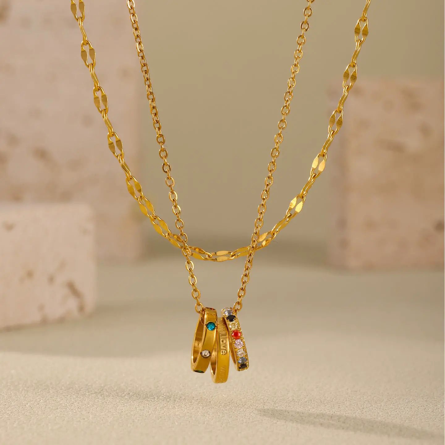 Close-up view of the With Love Triple Ring Necklace with multicolor zircon stones on a stainless steel chain, showing the intricate design and details.
