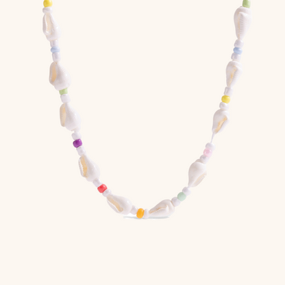 Close-up of the Coastal Candy necklace with colorful seed beads and natural shell details on a neutral background.