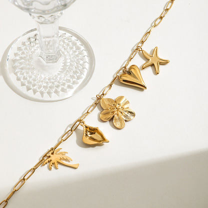 Ocean-inspired charm necklace with detailed pendants and wine glass reflection