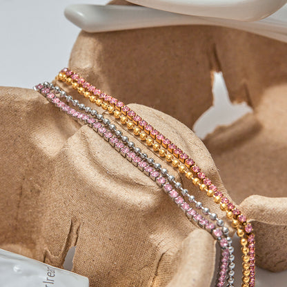 Pink and silver rhinestone bracelets stacked on kraft display with sunglasses