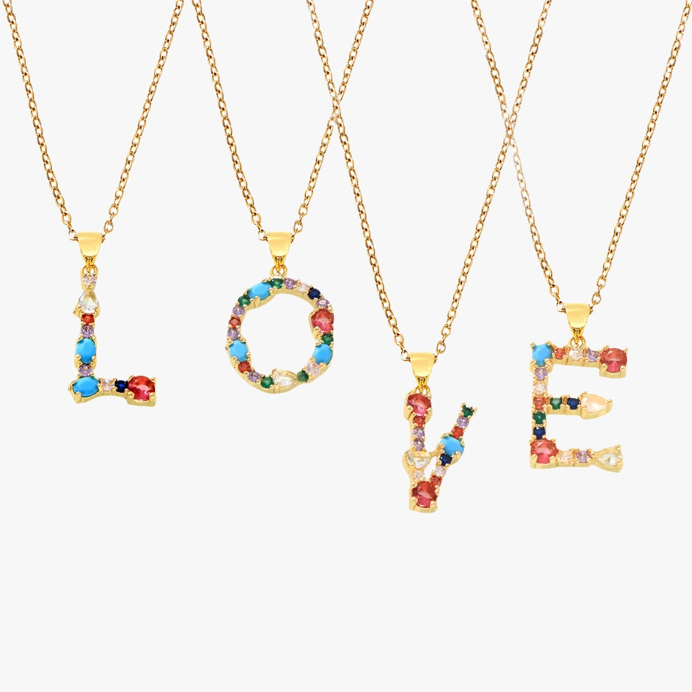'LOVE' pendant necklace with colorful zircon stones in red, blue, green, and yellow on a golden chain with a white background.