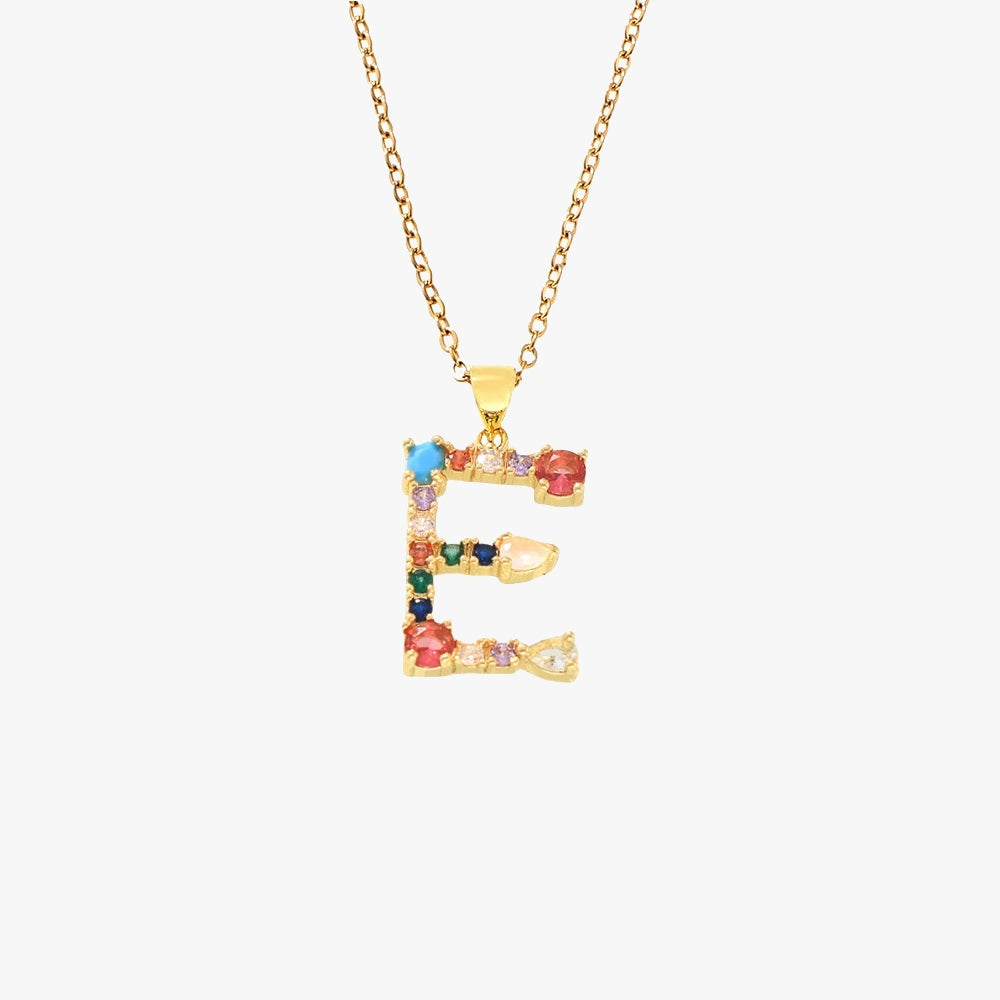 Letter E pendant in gold with colorful zircon stones in red, blue, and green, hanging from a gold chain.