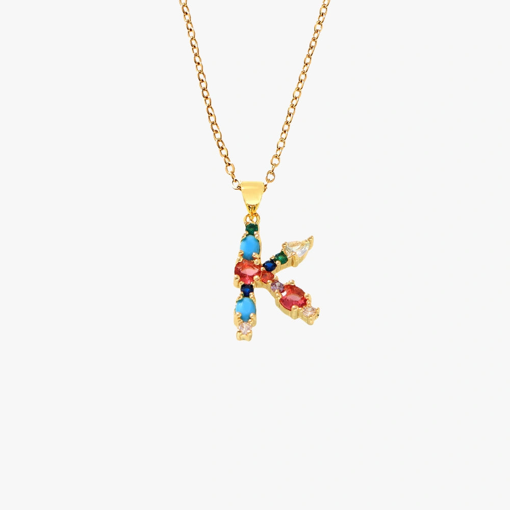 Golden letter K pendant with colorful zircon stones, including red, blue, and green hues on a delicate chain.