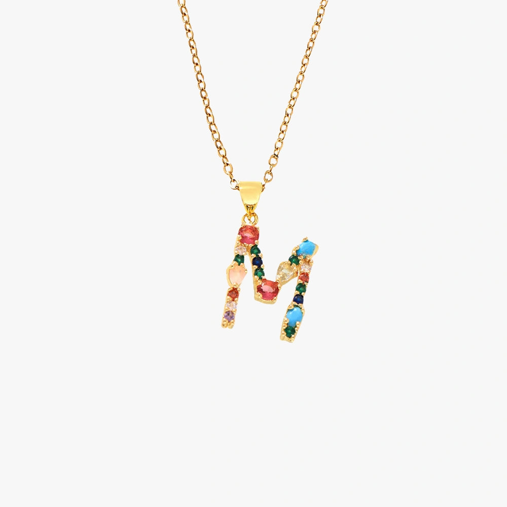 Gold letter M pendant with colorful zircon stones in vibrant red, blue, and green, on a fine gold chain.