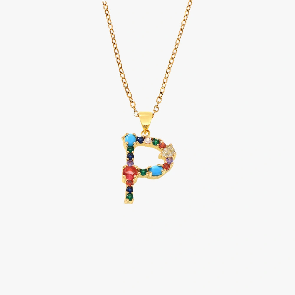 Golden pendant in the shape of the letter P, decorated with colorful zircon stones in red, blue, and yellow, hanging on a gold chain.