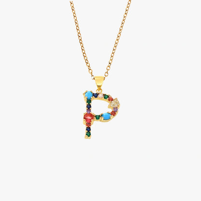 Golden pendant in the shape of the letter P, decorated with colorful zircon stones in red, blue, and yellow, hanging on a gold chain.