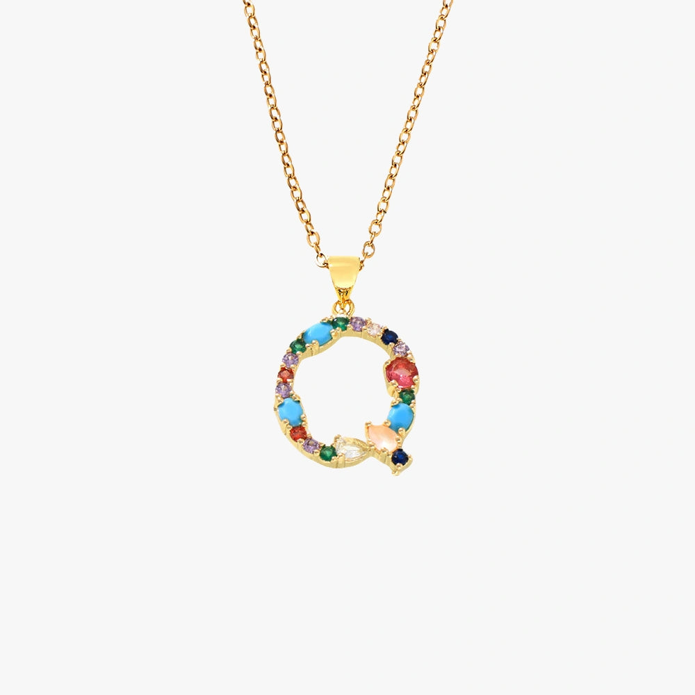 Golden pendant in the shape of the letter Q, adorned with vibrant zircon stones in red, blue, and yellow on a delicate chain.