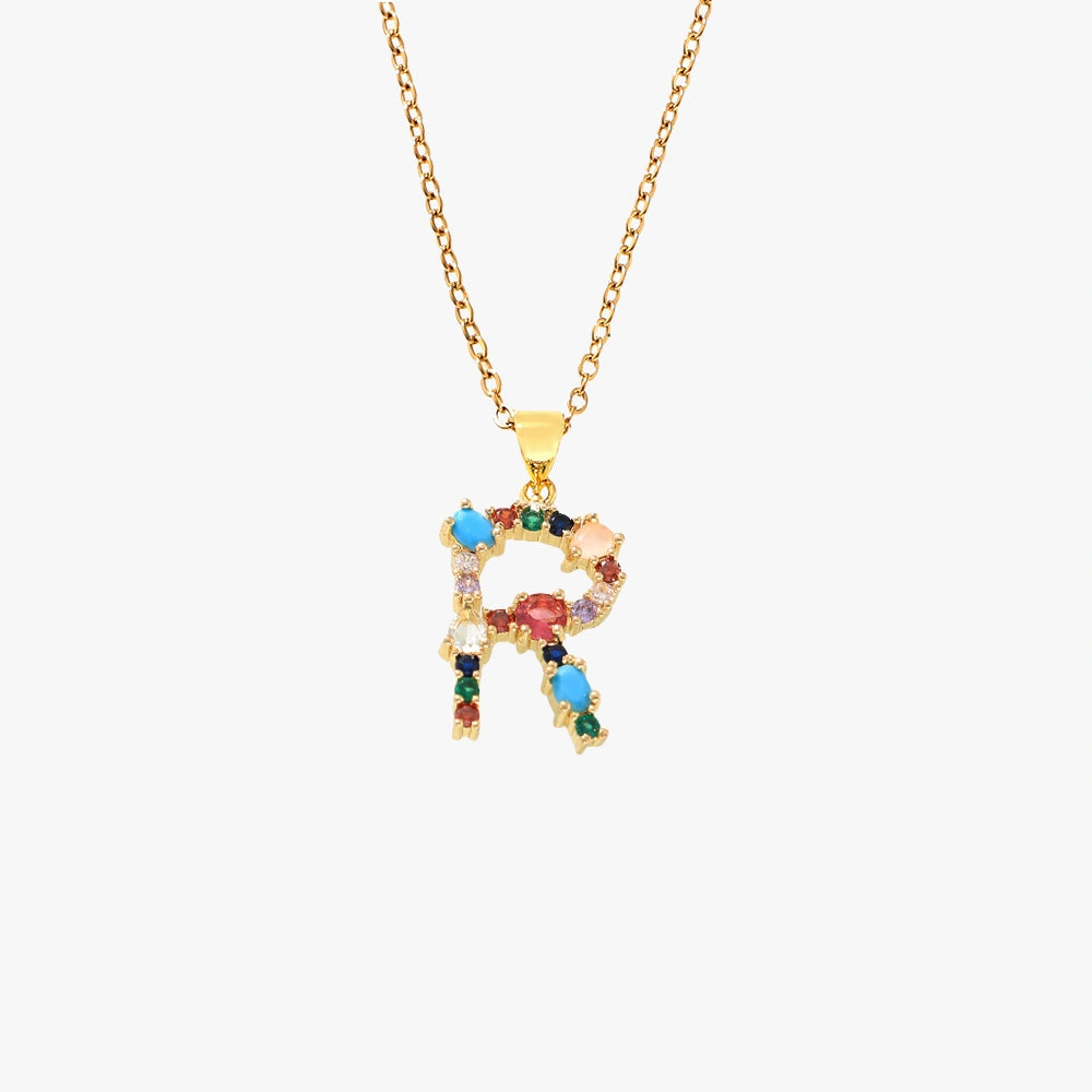 Gold letter R pendant with colorful zircon stones in red, blue, and green, suspended from a gold chain.