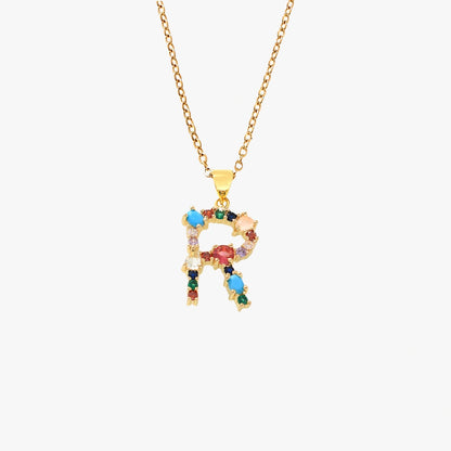 Gold letter R pendant with colorful zircon stones in red, blue, and green, suspended from a gold chain.