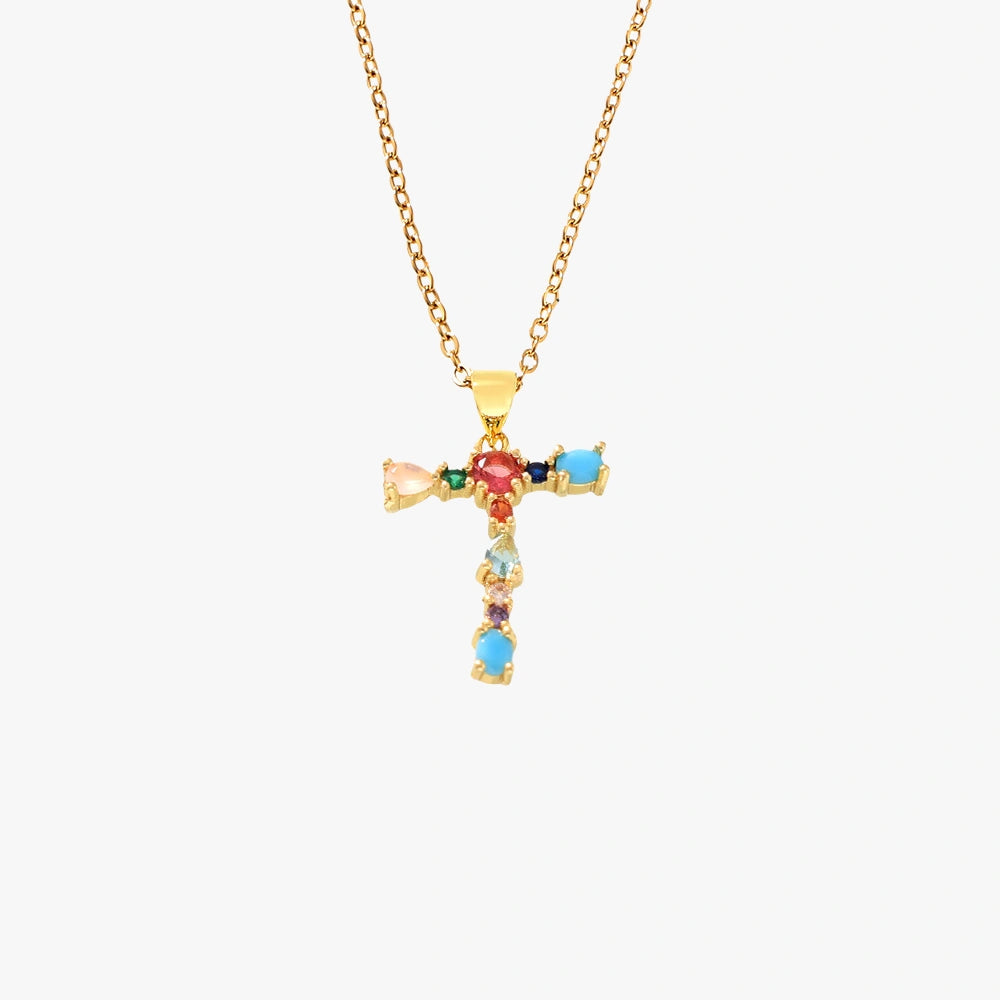 Golden letter T pendant adorned with vibrant zircon stones, hanging from a gold chain.