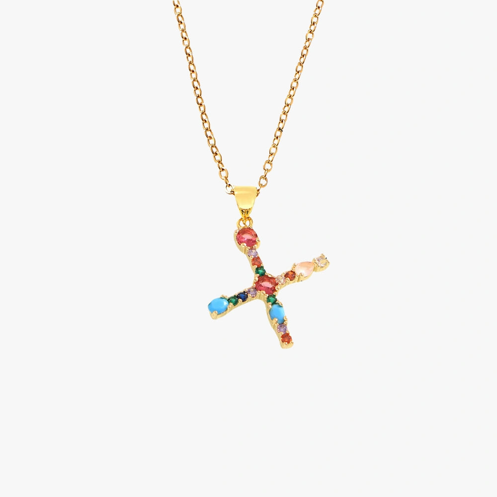 Gold pendant in the shape of the letter X, adorned with vibrant zircon stones in red, blue, and yellow, on a fine gold chain.