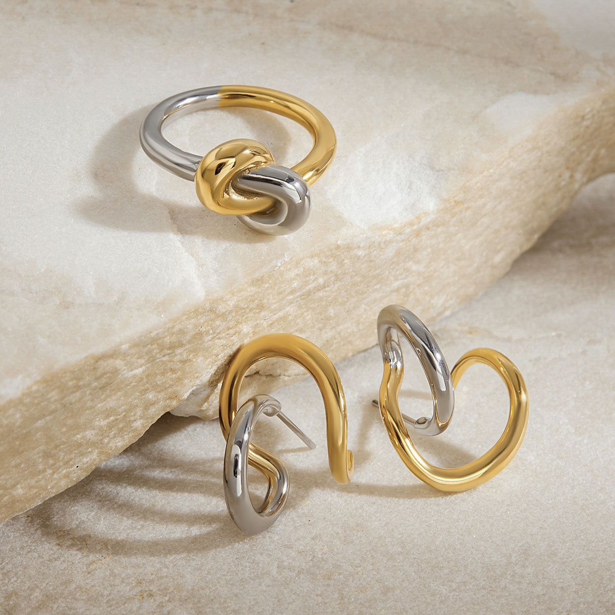Macro shot of modern gold and silver knot ring on white background