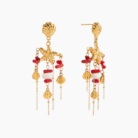 Gold earrings with red and white beads on a white background