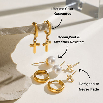 Gold cross hoop earrings paired with pearl studs in a light-filled setting