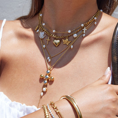 Flatlay of chunky Cuban bracelet with crystal heart and cross