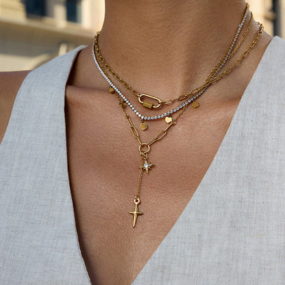 Close-up of a person wearing multiple gold necklaces with various pendants.